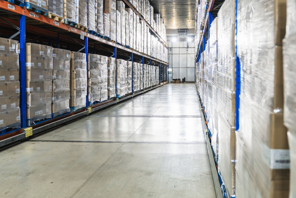 view down the aisle of a cold storage warehouse full of goods