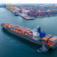cargo ship being assisted by a tugboat while arriving in port