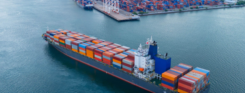 cargo ship being assisted by a tugboat while arriving in port