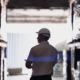 silhouette of a logistics worker with a hardhat walking through a warehouse