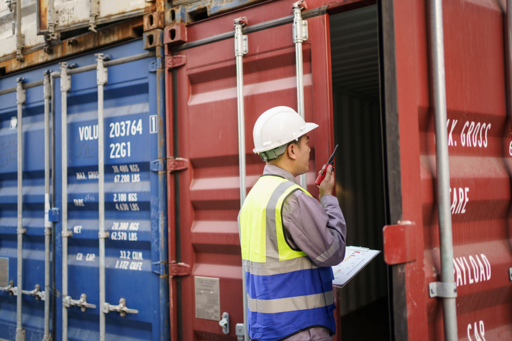 shipyard worker inspecting a cargo container