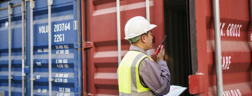shipyard worker inspecting a cargo container